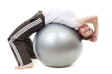 Iemand rekt de rug uit over een grote fitnessbal