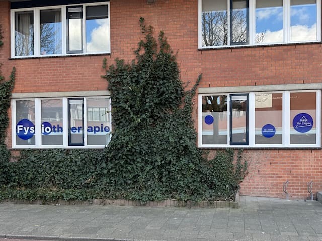 Het pand van de praktijk aan de Julianaweg, met Fysiotherapie op de ramen