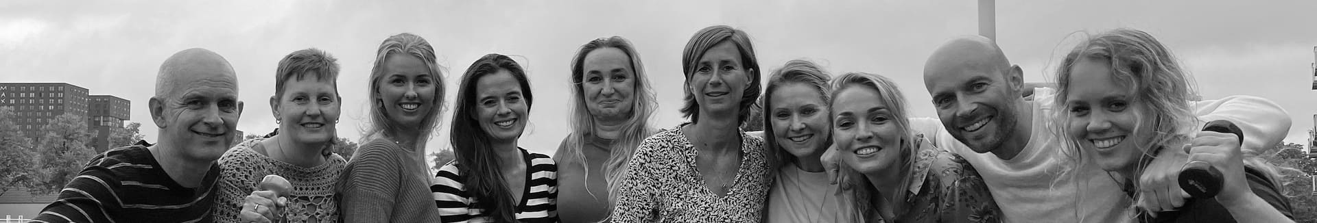 Het team van Praktijk Van Diepen naast elkaar buiten, in zwart-wit
